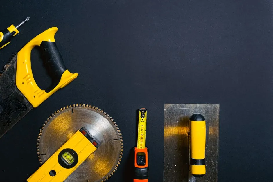Hand tools including saws, levels, and a tape measure arranged on a flat surface