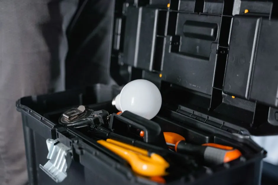 Open toolbox with assorted tools and a light bulb